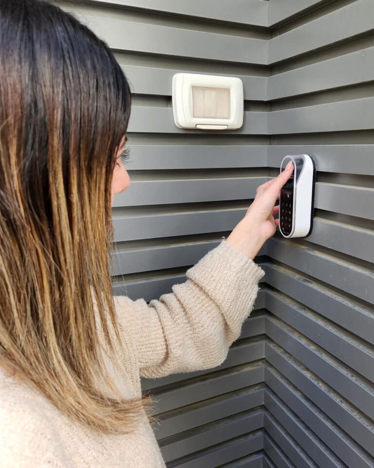 Entr מערכת נעילה חכמה 5 Fingerprint and touch code of an entr smart lock. Unit is on a decorated wall. A woman opens a door with a fingerprint.