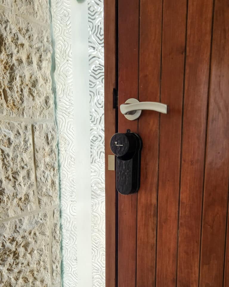 Entr מערכת נעילה חכמה 2 Smart lock _Entr_ black finish. A brown wooden door, installed by smart lock israel.