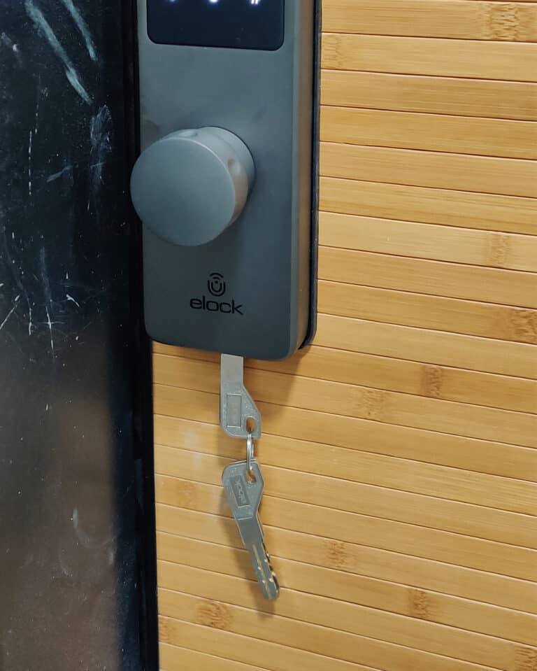 Elock Wize finish gray installed by smart lock israel. Keys in the lock. A door designed with wood cladding.